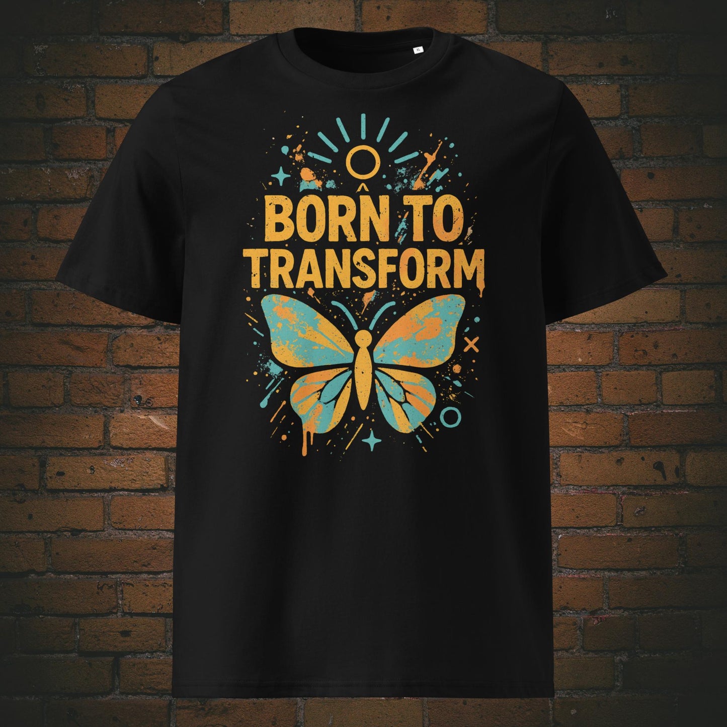 Schwarzes T-Shirt mit buntem Schmetterling und Spruch „Born to Transform“, modernes Graffiti-Design mit Farbspritzern, Sternen und Sonnenstrahlen.