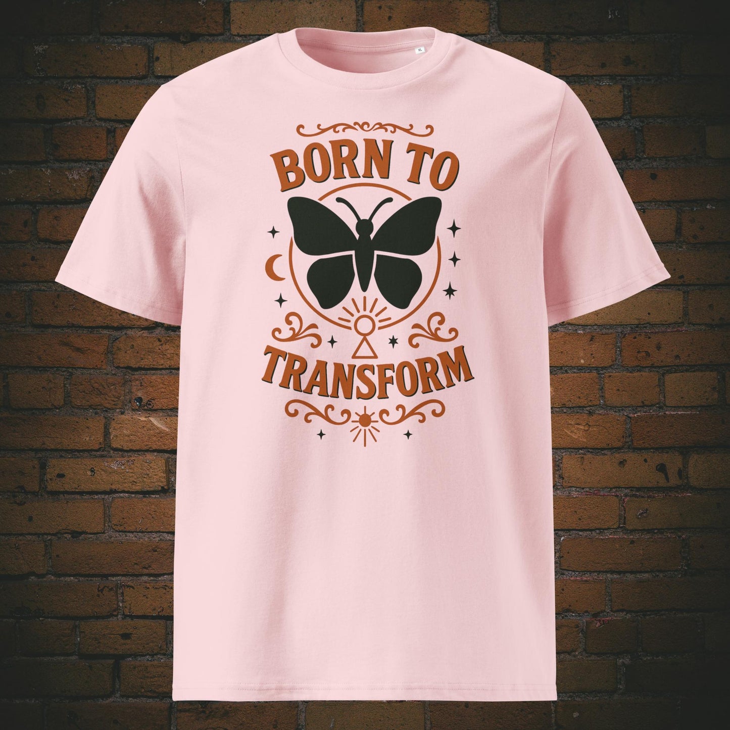 Rosa T-Shirt mit Schmetterlingsmotiv und Spruch „Born to Transform“, verziert mit spirituellen Symbolen wie Mond, Sternen und Schlüsselloch – Boho-inspiriertes Design.