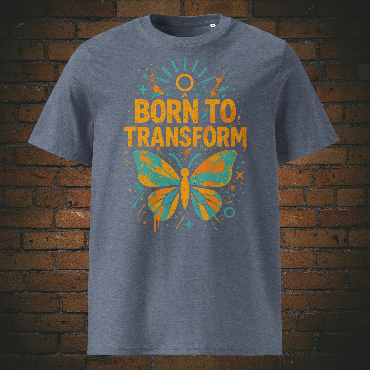 Graublau meliertes T-Shirt mit buntem Schmetterling und Spruch „Born to Transform“, modernes Graffiti-Design mit Farbspritzern, Sternen und Sonnenstrahlen.