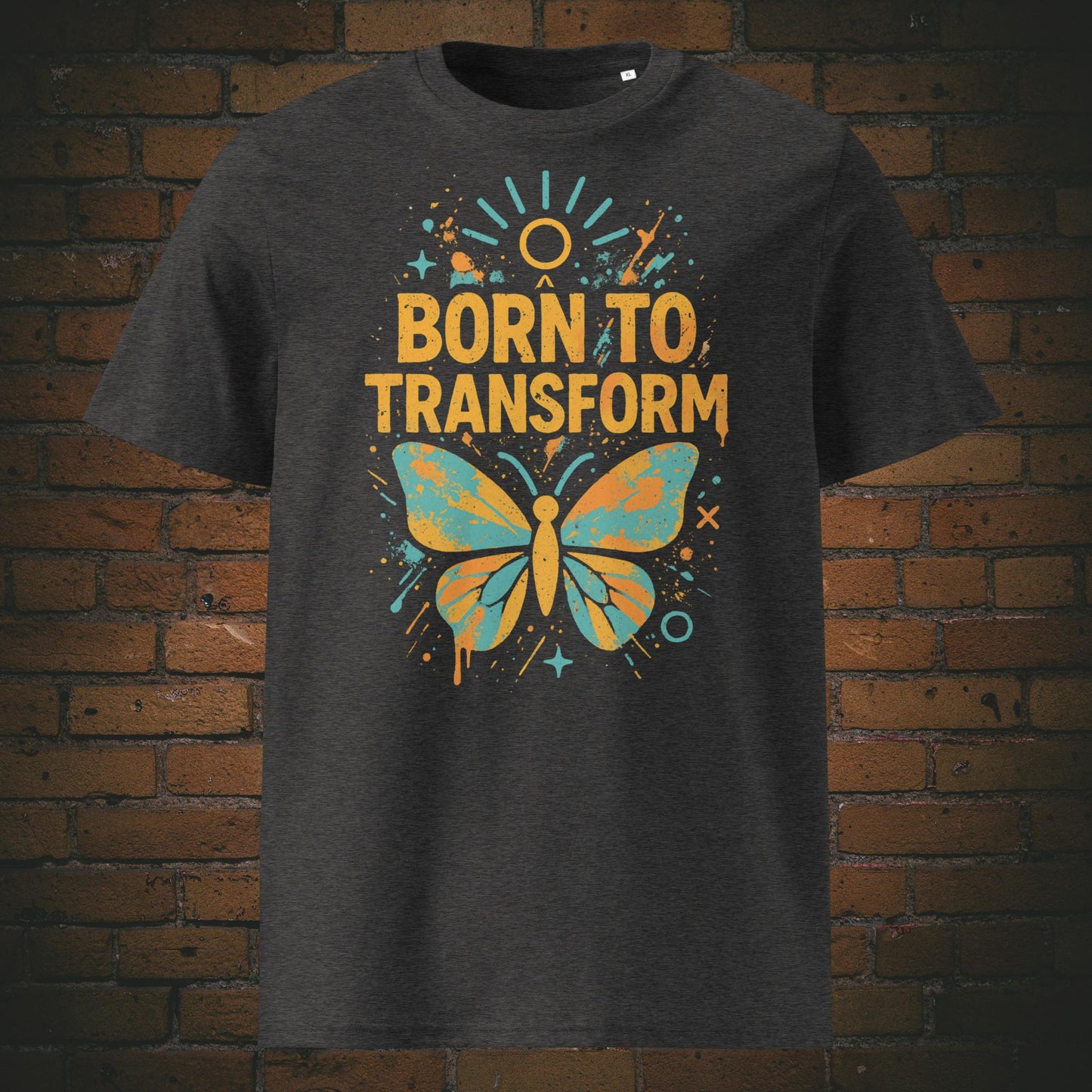dunkelgraues T-Shirt mit buntem Schmetterling und Spruch „Born to Transform“, modernes Graffiti-Design mit Farbspritzern, Sternen und Sonnenstrahlen.