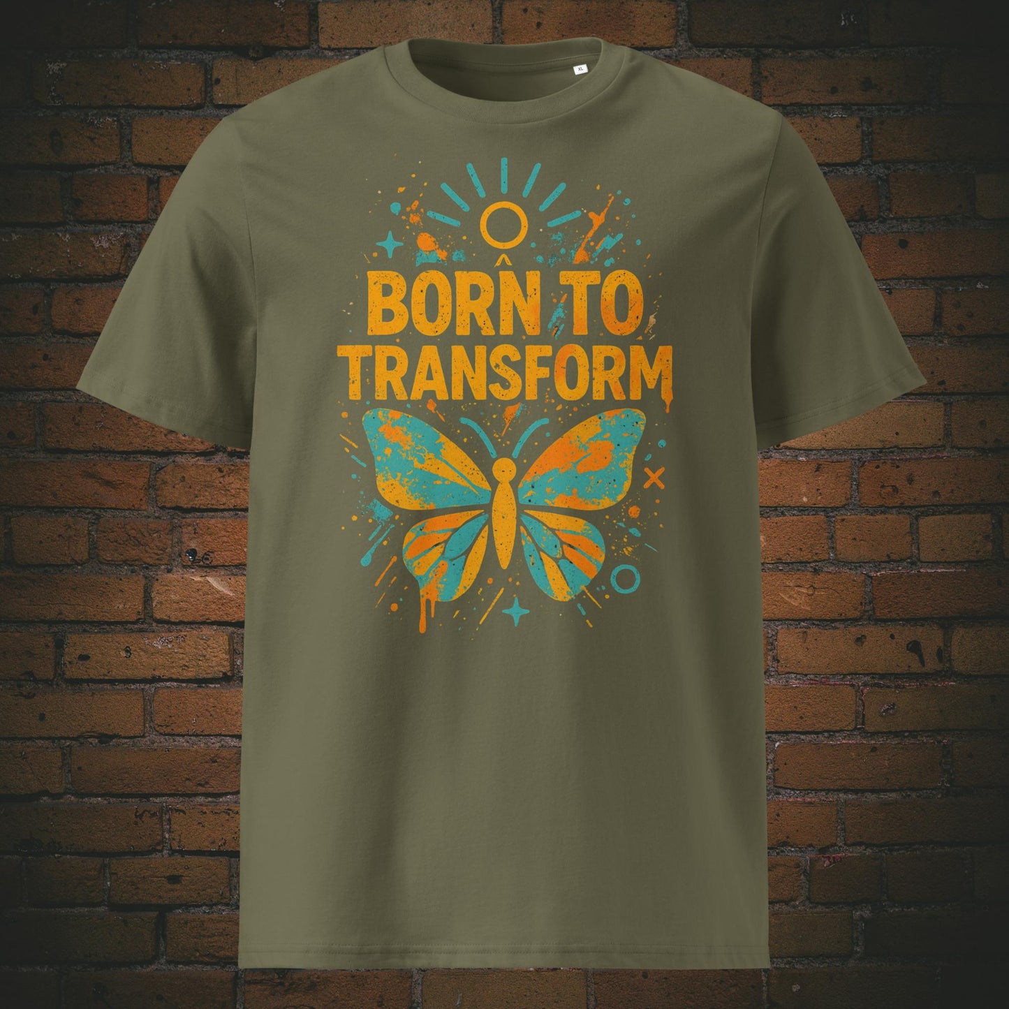 Khaki Farben T-Shirt mit buntem Schmetterling und Spruch „Born to Transform“, modernes Graffiti-Design mit Farbspritzern, Sternen und Sonnenstrahlen.